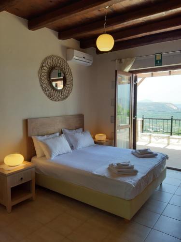 a bedroom with a large bed and a balcony at Villa Petra in Kalyves