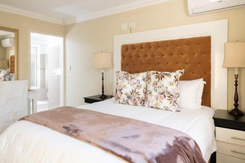 a bedroom with a large bed with a large headboard at Dikalo Highston Boutique Guest house in Bryanston Sandton Johannesburg in Johannesburg