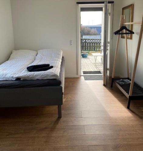 a bedroom with a bed and a door to a balcony at Surfers Paradise Apartments in Hvide Sande
