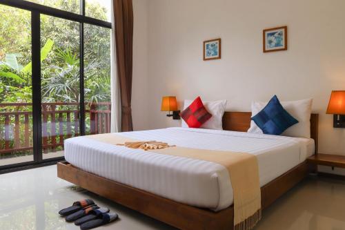 a bedroom with a large bed and a large window at The Choice Hotel - Adults Only in Bangkok