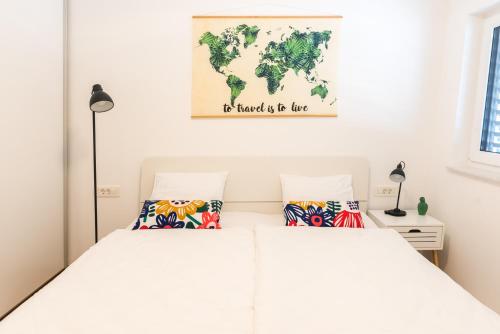 1 dormitorio con 2 camas y un mapa mundial en la pared en Apartment ALMA - to travel is to live en Celje