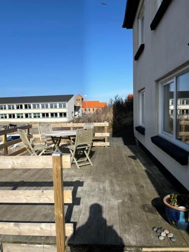 patio ze stołem i krzesłami oraz budynek w obiekcie Surfers Paradise Apartments w mieście Hvide Sande