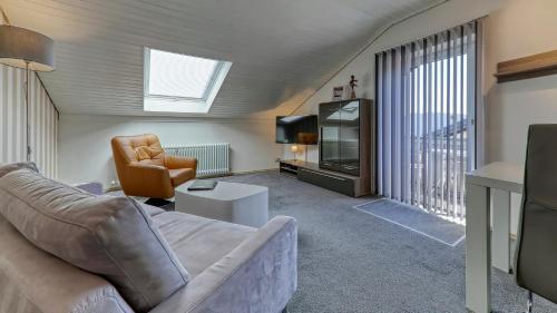 a living room with a couch and a tv at Suit' & Frühstück Zum Latschen - Adults Only in Mauth
