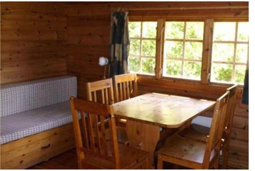 una sala da pranzo con tavolo e panca in una cabina di Bygholm Camping a Vesløs