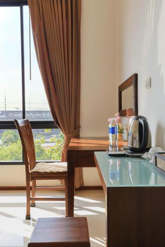 a room with a desk and a chair and a window at The Choice Hotel - Adults Only in Bangkok