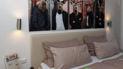 a bedroom with three pictures on the wall above a bed at Suit' & Frühstück Zum Latschen - Adults Only in Mauth
