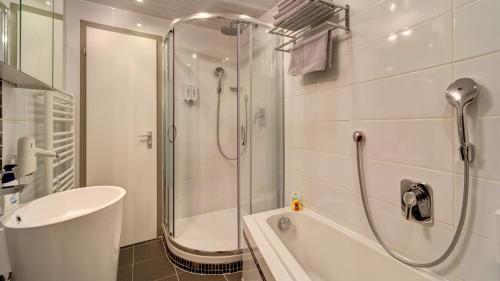a bathroom with a shower and a tub and a sink at Suit' & Frühstück Zum Latschen - Adults Only in Mauth