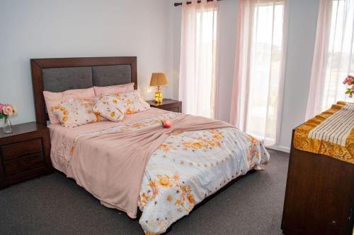 a bedroom with a large bed with flowers on it at Botanical Guest House in Mickleham