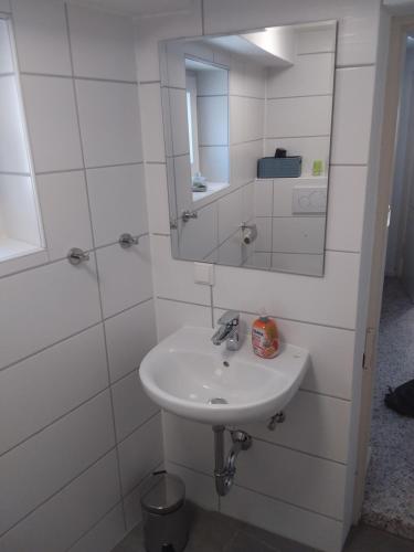 a white bathroom with a sink and a mirror at Ferienwohnung Jansen "Zwei" in Bad Schwalbach