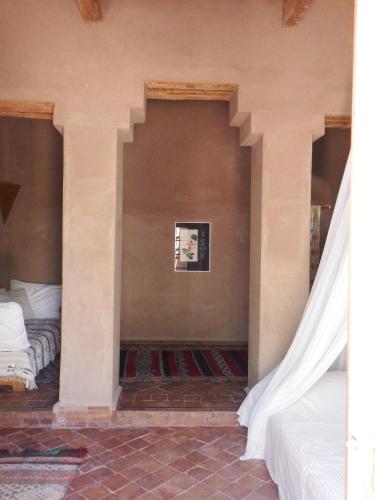 a bedroom with two beds and a wall at Dar Paru in Mhamid