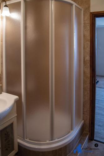 a shower stall in a bathroom with a sink at FruPi-Apartmanok in Ostoros