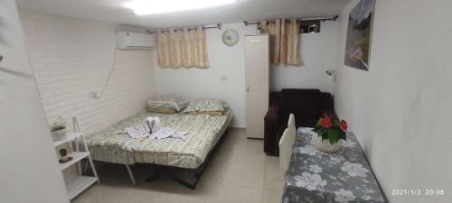 Habitación pequeña con 2 camas y mesa. en Yair room apartment, en Jerusalén