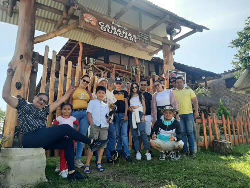 a group of people standing in front of a wooden building at Cabañas Guacari San Agustín huila in San Agustín