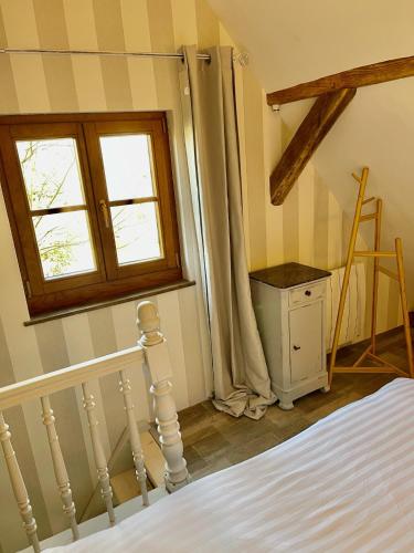 a bedroom with a bed and a window at La Ferme de Marie in Rangen
