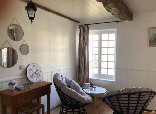 uma sala de estar com uma cadeira, uma mesa e uma janela em CHAMBRE D'HOTE AU MOULIN DE LONGUEIL em Longueil