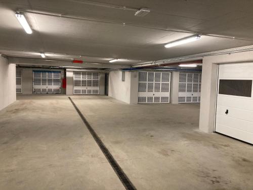 an empty garage with white doors and concrete floors at JAB Apartament Przy Klinice Business & Family in Szczecin