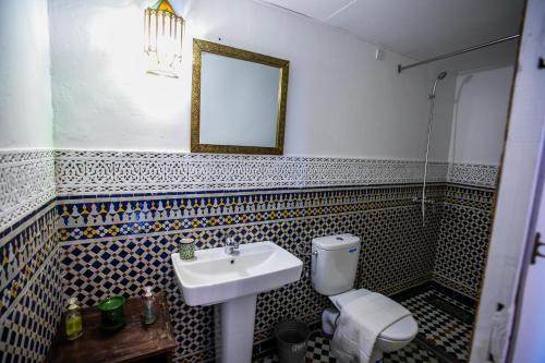 a bathroom with a sink and a toilet and a mirror at Riad Arabella in Fès