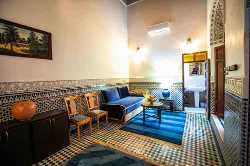 a living room with a blue couch and a table at Riad Arabella in Fès