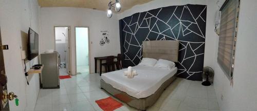 a bedroom with a bed with a geometric wall at DJCI Apartelle with own Kitchen & Bath 103-212 in Cabanatuan