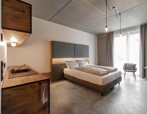 埃欣根的住宿－GH1 Aparthotel am Glockenplatz，一间卧室配有一张床、一张桌子和一把椅子