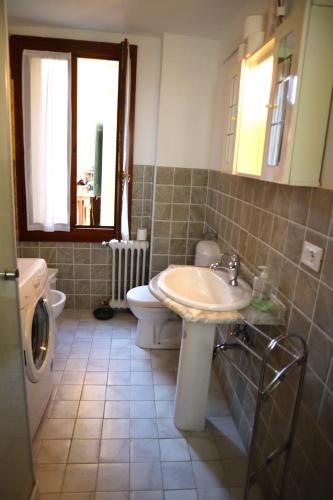 a bathroom with a sink and a toilet and a window at VENICE RAINBOW APARTMENT (RIALTO) in Venice