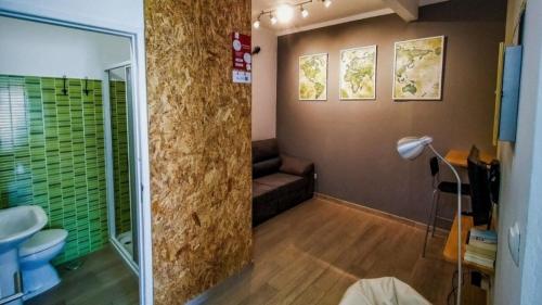a bathroom with a couch and a glass shower at Roots Apartment in Zambujeira do Mar