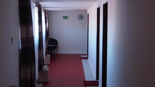 a hallway with a red floor and stairs in a building at Penzion a Restaurace Na Jízdárně in Kroměříž