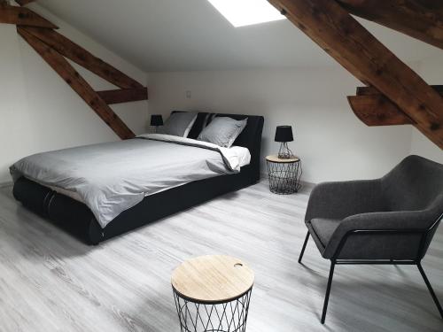 a bedroom with a bed and a chair and a table at Loc'citanie chambres double in Aussillon