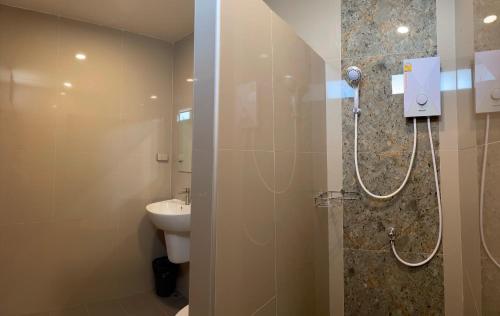uma casa de banho com um chuveiro, um WC e um lavatório. em Sinai Hotel em Rayong