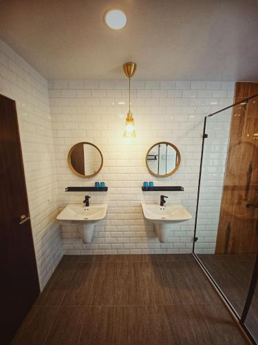 a bathroom with two sinks and two mirrors at 埔里隱巷人文行旅民宿 in Puli