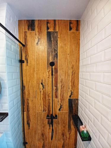 a shower in a bathroom with a wooden wall at 埔里隱巷人文行旅民宿 in Puli