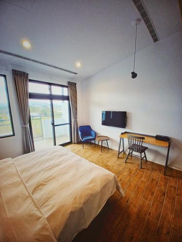 a bedroom with a bed and a table and a tv at 埔里隱巷人文行旅民宿 in Puli