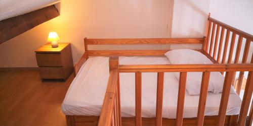ヴィルヌーヴ・ルベにあるRésidence Cap Azur Appartement 218の木製の二段ベッド(ナイトスタンドにランプ付)