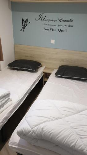 two beds sitting next to each other in a room at Camping Les charmette les maths la palmyre in Les Mathes