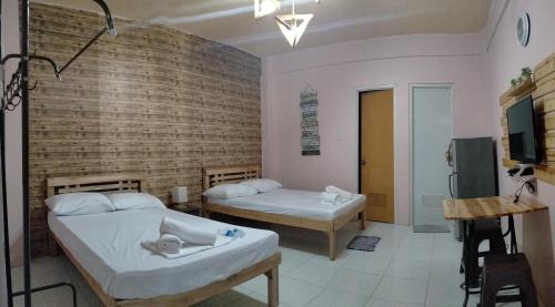 a bedroom with two beds and a tv in it at DJCI Apartelle with own bath & kitchen 101-211 in Cabanatuan