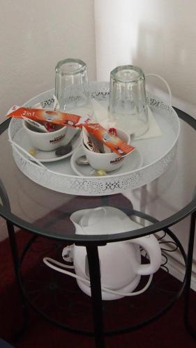 a glass table with bowls and glasses on top of it at Penzion a Restaurace Na Jízdárně in Kroměříž
