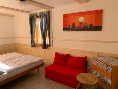 ein Schlafzimmer mit einem Bett und einem roten Sofa in der Unterkunft Retro chatky Hůrka Lipno in Horní Planá