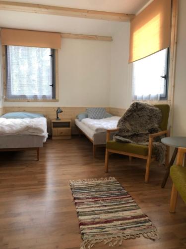 a room with two beds and a rug at Retro chatky Hůrka Lipno in Horní Planá