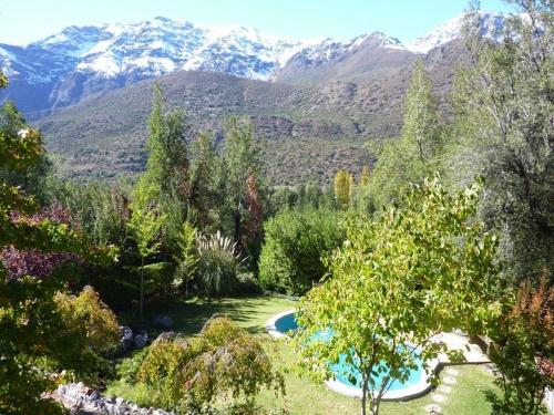 a view of a garden with mountains in the background at Casa de Montaña inmersa en Bosque Nativo in San José de Maipo