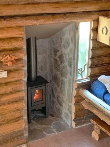 a fireplace in a log cabin with a stove at Cabaña Suiza in Cacheuta