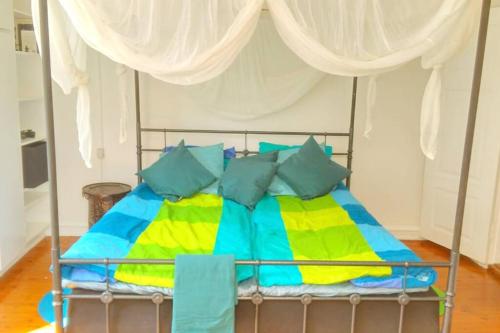 a bed with colorful sheets and pillows in a room at The nicest house with internet in Rudkøbing