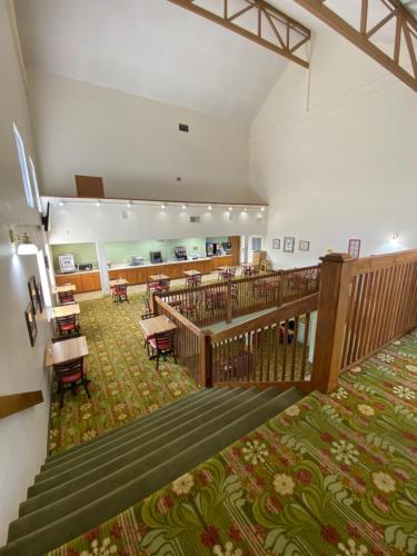 a large room with stairs and tables and chairs at Brookwood Inn Branson in Branson