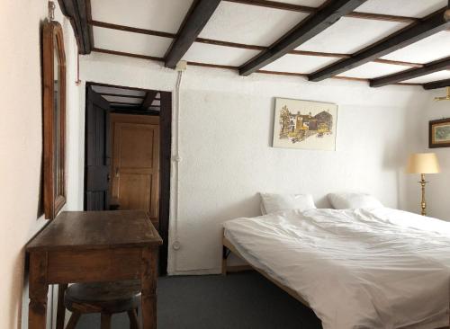 a bedroom with a bed and a wooden table at Casa al Vento in Bidogno