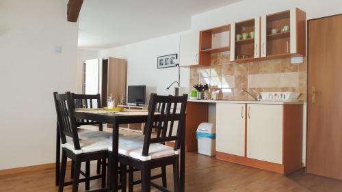 a kitchen with a table and chairs in a room at Penzion Zelený Háj in Merklín