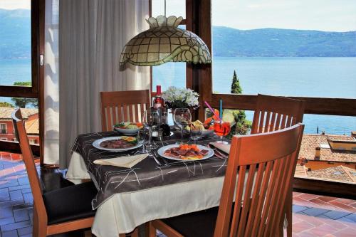 a table with food and a view of the water at Hotel Palazzina in Gargnano