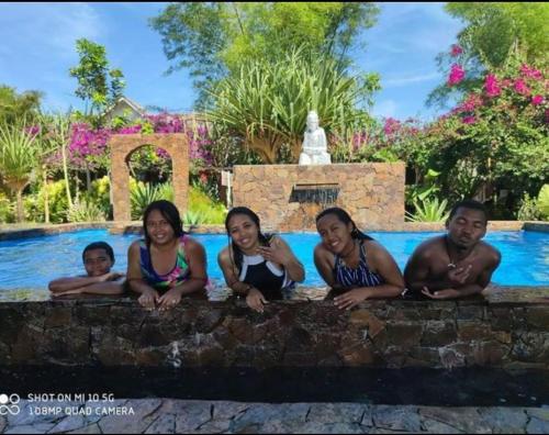 a group of people sitting next to a swimming pool at Hotel ECOLODGE LE RAVORAHA in Sainte Marie