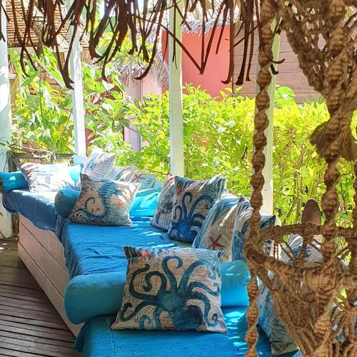 a blue couch with pillows sitting on a porch at Hotel ECOLODGE LE RAVORAHA in Sainte Marie
