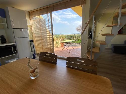 a kitchen with a wooden table with a vase on it at Maison de la Mer in Port Leucate