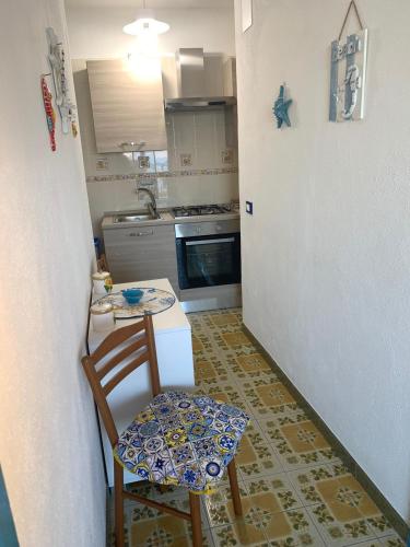 a small kitchen with a table and a chair at Appartamenti Tina in Villa Restituta in Ischia
