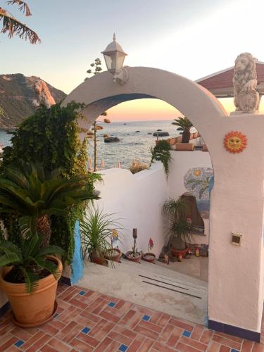 an archway with plants and a view of the ocean at Appartamenti Tina in Villa Restituta in Ischia